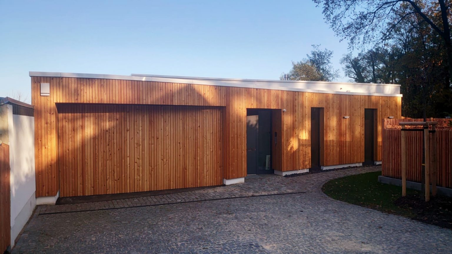 Holzfassade mit senkrechter Lattung im warmen Abendlicht